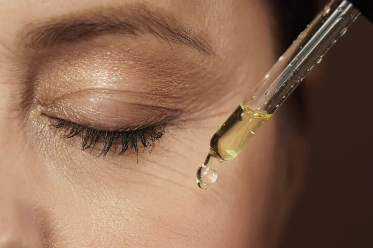 Close-up of eye area receiving hydrating serum, illustrating ectoine’s role in protecting delicate skin from environmental stress and dehydration