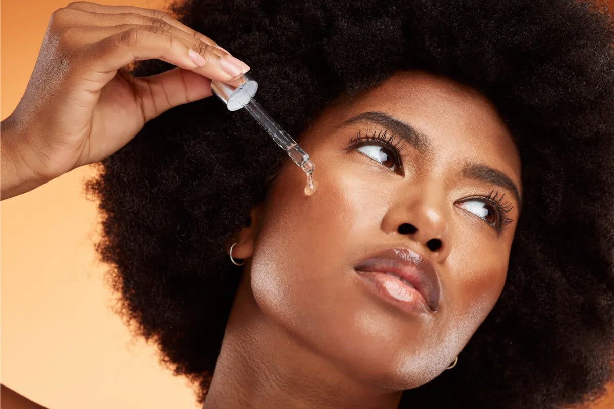 Woman with rich, glowing skin applying a serum – suitable for retinaldehyde use in diverse skin tones