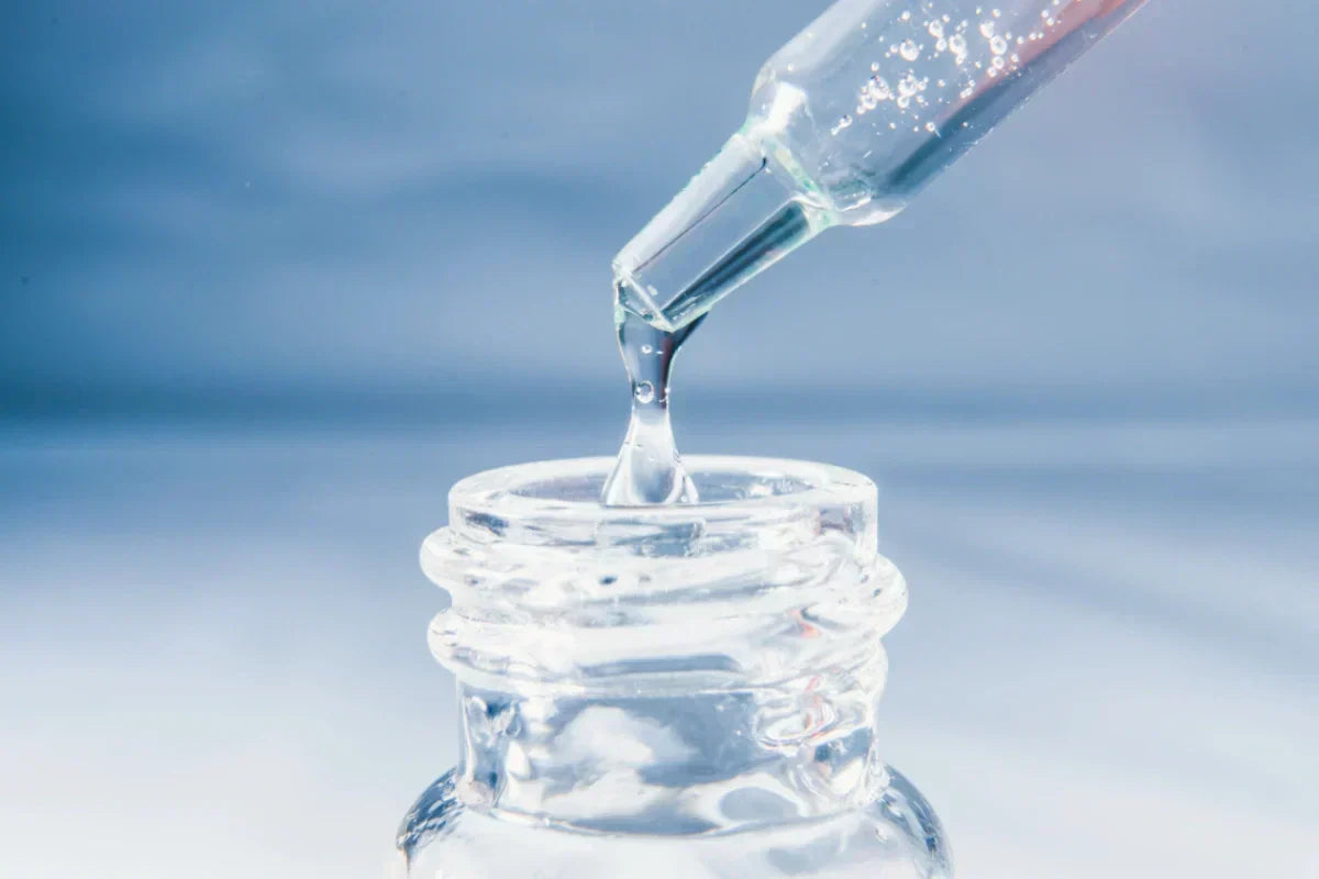 Pure glycerine serum dropper dispensing clear liquid into a glass bottle for skincare use