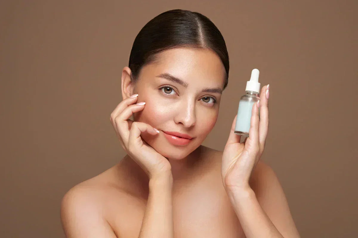 ALT: "Young woman holding a serum bottle, illustrating hyaluronic acid for hydrated, youthful skin