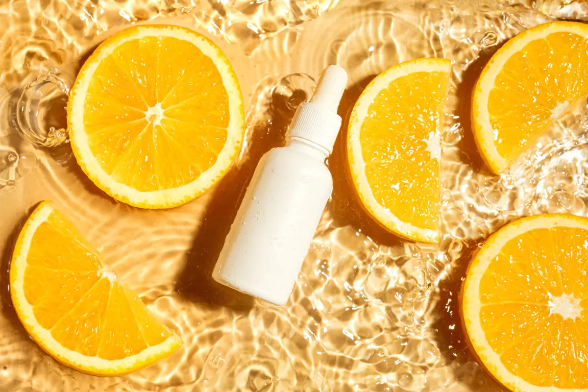 Vitamin C serum bottle surrounded by fresh orange slices highlighting antioxidant skincare.