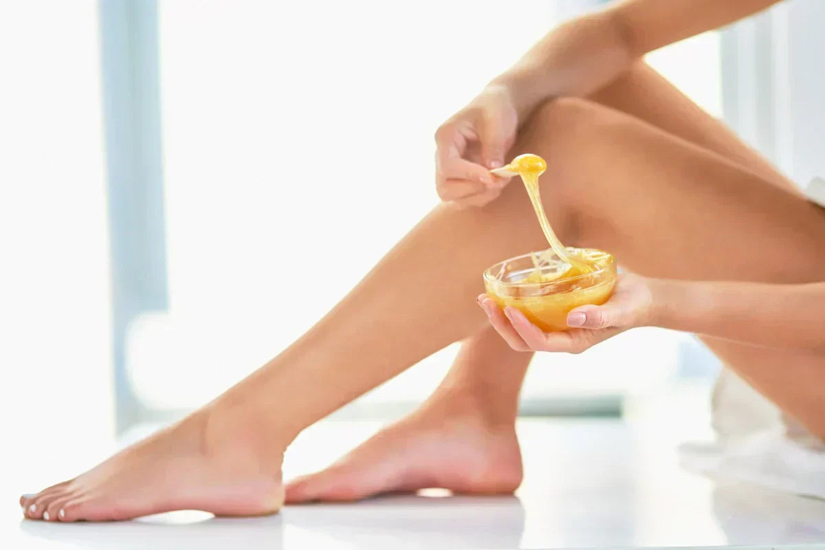 Woman applying warm wax for smooth skin, demonstrating skincare and cosmetic wax application